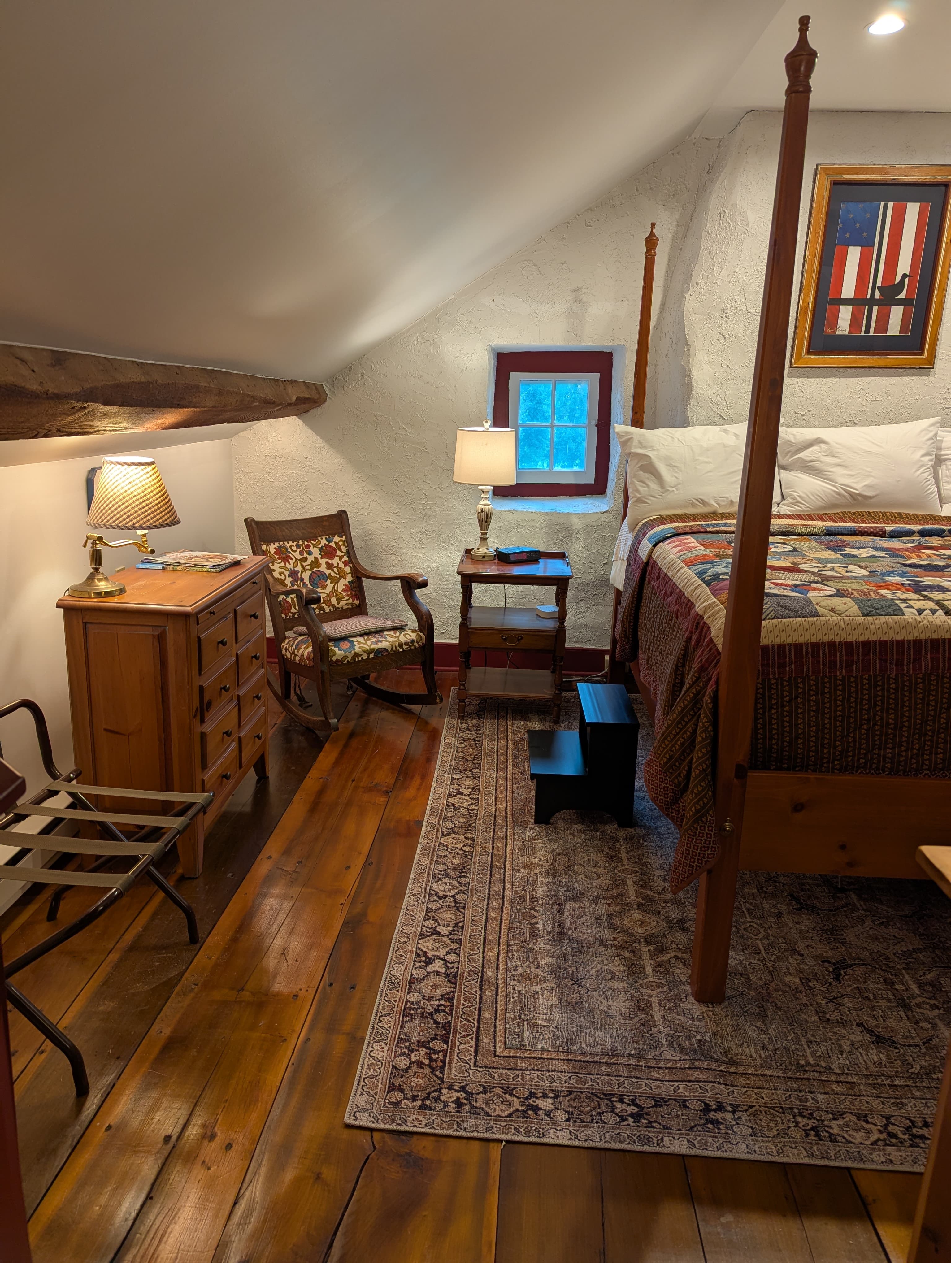 Bedroom scene with bed and small sitting area